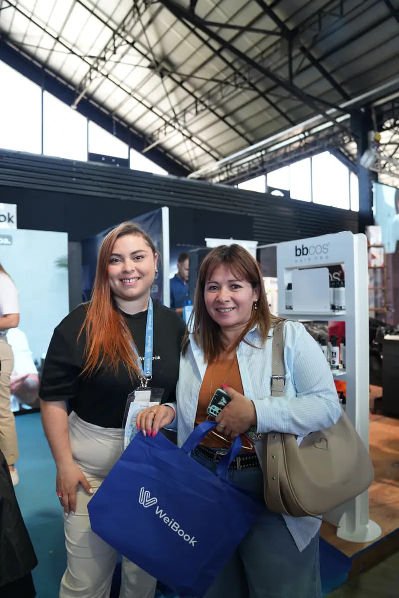 Advisor and client pose with a WeiBook tote bag in Argentina